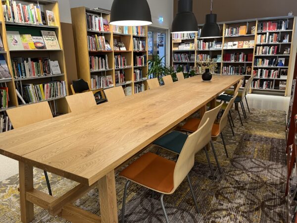 Eit langbord med stolar rundt i biblioteklokalet. Foto